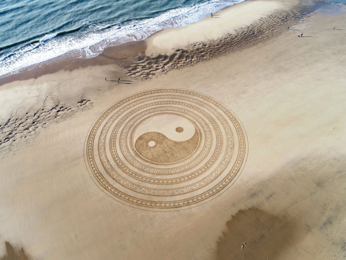 yin and yang sign on a beach